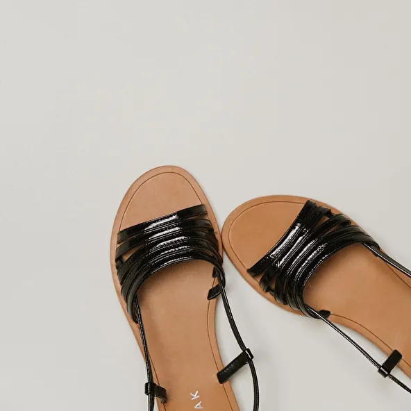 Strappy sandals with open toes in black patent